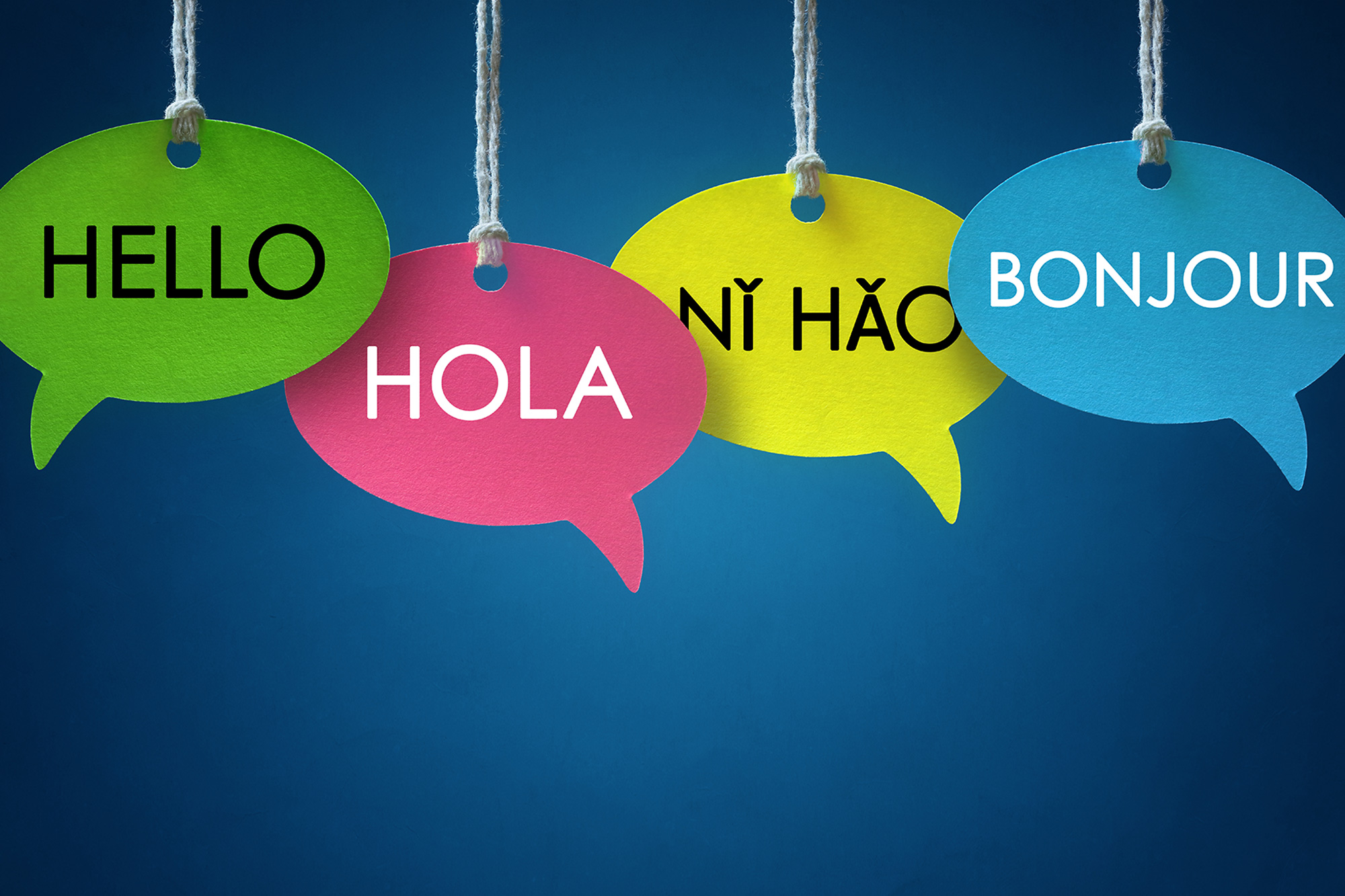 Globos de diálogo multicolores con "Hola" en varios idiomas.