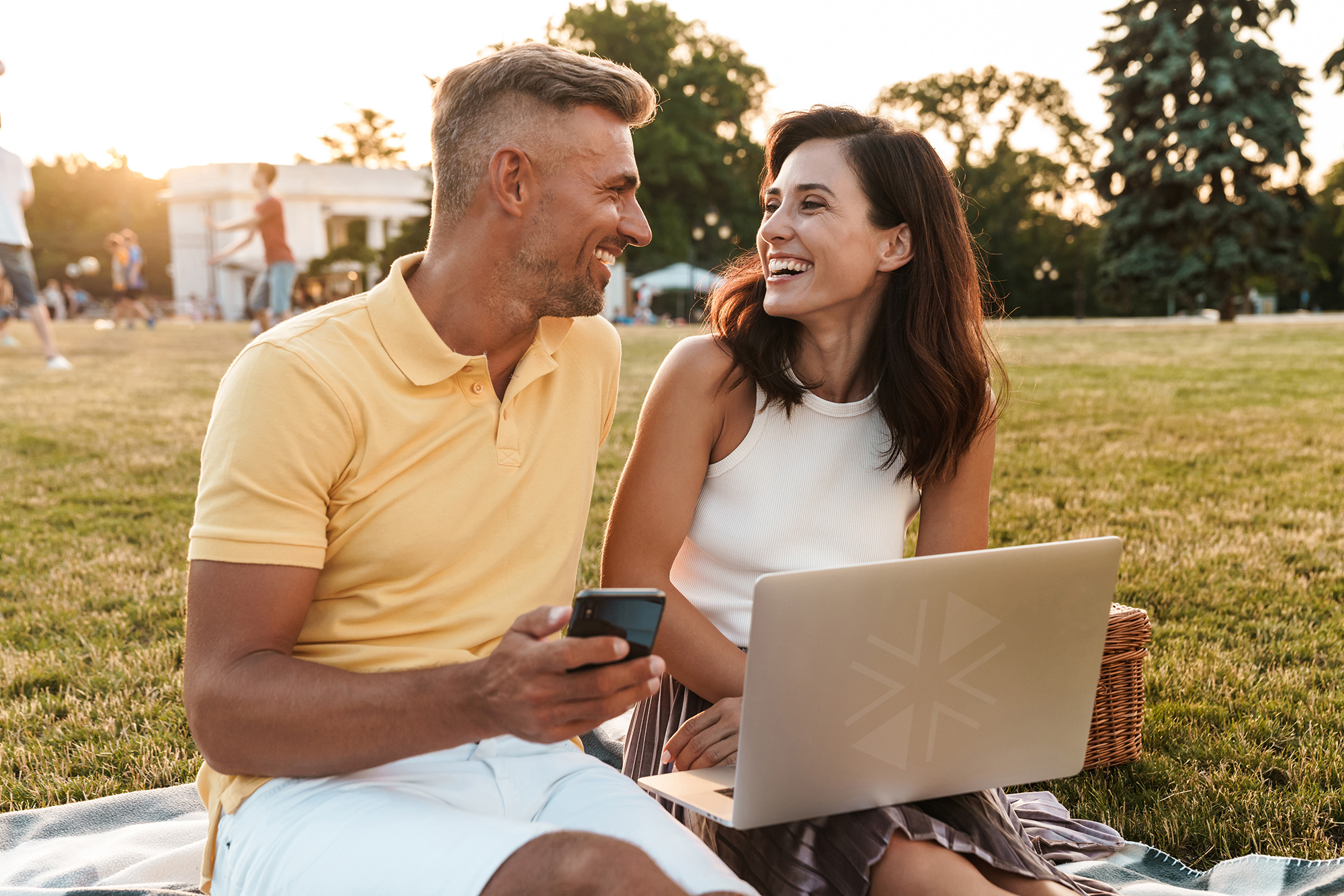 Two people smiling at each other outside.